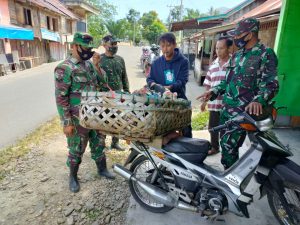 Anggota Satgas TMMD/N Melakukan Komunikasi Sosial Dengan Penjual Ayam