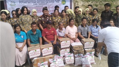 Kajari Samosir Karya Graham Hutagaol dan Ketua IAD Cabang Samosir Ny Helmi Karya Graham berserta rombongan berswafoto bersama keluarga korban bencana puting beliung. (KjriSmsir)