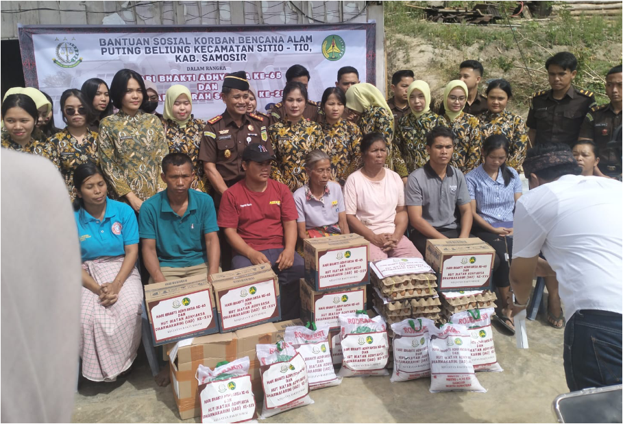 Kajari Samosir Karya Graham Hutagaol dan Ketua IAD Cabang Samosir Ny Helmi Karya Graham berserta rombongan berswafoto bersama keluarga korban bencana puting beliung. (KjriSmsir)